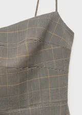 Vestido corto gris con estampado de cuadros, escote corazón y tirantes finos.