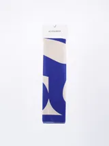 Pañuelo rectangular con estampado abstracto en tonos terracota, negro, blanco y beige.