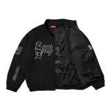 Campera negra de nylon con cierre frontal, bolsillos laterales y logo "Supreme" bordado en blanco en el pecho.