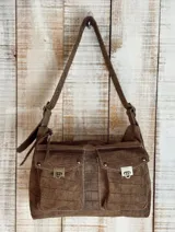 Bolso bandolera color borgoña con textura símil piel de cocodrilo, con correa fina ajustable y dos bolsillos frontales con cierre de broche metálico.