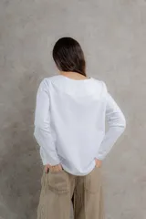 Remera negra de manga larga con costuras decorativas en color ocre en hombros y escote.