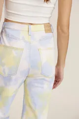Pantalón de jean de tiro alto con estampado tie-dye en tonos celeste, amarillo y blanco.
