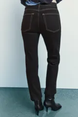 Pantalón de jean marrón oscuro, de tiro alto, corte slim fit y bootcut, con cinco bolsillos y pespuntes a contraste.