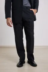 Traje de vestir negro de corte clásico, compuesto por saco con solapa de muesca y pantalón de vestir recto.