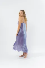 Vestido midi color lila metálico de breteles finos regulables, escote en V y ruedo asimétrico con leve vuelo.