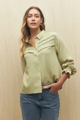 Camisa celeste de manga larga confeccionada en viscosa ligera, con detalles calados en la parte superior y pequeños volados.