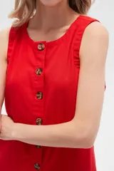 Vestido blanco de lino, corte entallado, con botones frontales, cuello a la base y breteles anchos.