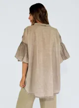 Camisa color lila con textura de lunares en relieve, de corte holgado, manga 3/4 con volados y cierre frontal con botones.