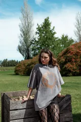 Remerón gris con cuello redondo y mangas cortas, con estampado de sol y luna en color ocre.