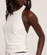 Blusa blanca de encaje con escote halter y espalda descubierta.