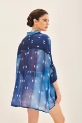 Camisa de seda estampada con diseño batik en tonos azules y blancos, corte amplio y mangas al codo.