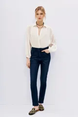 Pantalón jean slim azul oscuro, de tiro alto y corte ajustado.