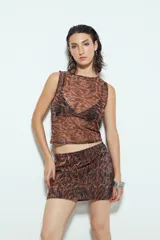 Minifalda ajustada con estampado animal print en tonos marrones y negros, con acabado brillante.