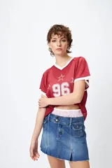 Minifalda de jean tiro bajo color negro con silueta evasé, dos tajos delanteros y ruedo desflecado.