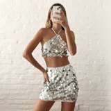 Top plateado con lentejuelas, de corte halter y espalda descubierta.