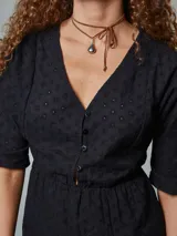 Vestido corto blanco con bordado broderie, escote en V y mangas cortas.