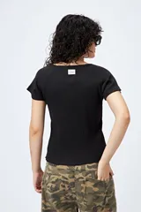 Remera color beige de punto acanalado con silueta relajada y manga corta raglán. El ruedo tiene terminación ondulada. El tejido con elasticidad ligera brinda comodidad y movimiento.