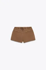 Shorts color marrón de algodón con efecto lavado, tiro medio, cintura elástica ajustable con cordones y detalle de tachas plateadas.