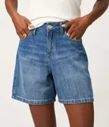 Bermuda de jeans azul oscuro, con trabillas en la cintura, bolsillos laterales y traseros, y cierre de botón y cremallera.