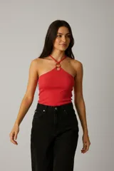 Top ajustado de algodón acanalado color rojo, con cuello halter asimétrico que se une en el centro con un aro decorativo de madera.