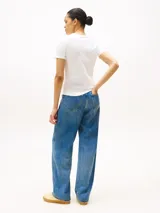 Remera blanca de corte slim, cuello redondo y manga corta. Presenta un logo estampado en el pecho.