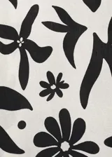 Pantalón wide leg de viscosa con estampado floral en blanco y negro. Tiene cintura elástica, dos bolsillos laterales y diseño largo.