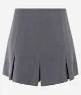 Short pollera gris de corte sastrero con pliegues anchos delanteros y traseros, y cierre invisible lateral.