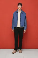 Pantalón de vestir negro con pliegues, corte recto y bolsillos laterales.