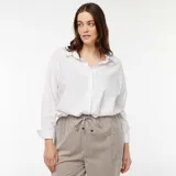 Camisa blanca de corte holgado, manga larga y cuello clásico.