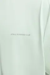 Camiseta deportiva verde claro confeccionada en tejido técnico, ligero y elástico en cuatro direcciones. Tiene cuello redondo, manga corta, zonas con estructura perforada y logo estampado.