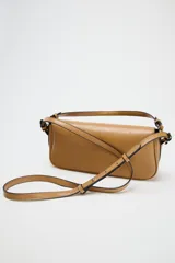 Bolso bandolera color caramelo, con doble asa: una asa larga regulable y una asa de hombro. Tiene bolsillo interior con cierre mediante cremallera metálica y solapa con cierre imantado.