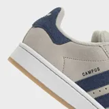 Championes Adidas Campus 00s color gris claro con detalles en azul marino. Presentan las tres tiras características de Adidas en el lateral y suela blanca con base color caramelo.