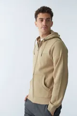 Campera de felpa color beige con cierre frontal, capucha con cordón ajustable, bolsillos laterales y logo estampado en el pecho.