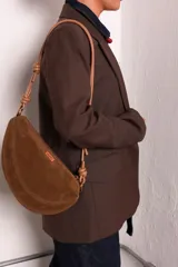 Cartera tipo sobre color bordó, confeccionada en PU tipo gamuza, con correa regulable de nudos chunky y cierre superior.