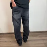 Jean de hombre color negro con efecto lavado, de corte mom fit, con cintura elástica y puños ajustados en los tobillos.