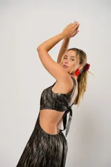 Vestido largo de fiesta con estampado abstracto en tonos dorados y negros. Tiene escote en V, corte en la cintura y aberturas laterales.