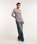 Blusa de viscosa color gris con efecto gastado, cuello redondo, mangas largas, fruncido lateral y abertura.