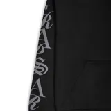 Campera con capucha y cierre frontal completo, color negro, con logo Trapstar en el pecho y estampado de letras en la manga izquierda.