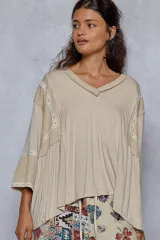 Blusa color beige de corte amplio, con escote en V, mangas 3/4 y detalles de ribetes en broderie.