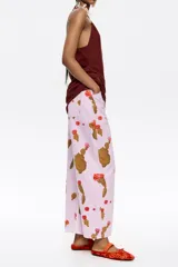 Pantalón de jean color lila con estampado de cactus marrones con flores naranjas. Corte recto, tiro medio y largo tobillero.