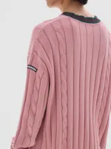 Buzo tejido de ochos color verde oscuro, con cuello a la base y rayas contratono en puños y cuello.