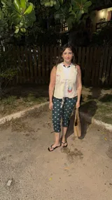 Pantalón capri ajustado color verde oscuro con estampado de lunares rosados. Tiene elástico en la cintura y un cierre lateral.