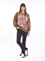 Buzo color beige con estampado de flores y texto en blanco.