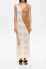 Vestido midi de crochet con diseño color block en crudo y marrón, escote en V y corte recto con aberturas laterales.