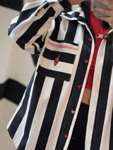 Camisa oversize de jean rayado blanco y negro con bolsillo con bordado de corazón con fuego y botones de acrílico en forma de corazón.