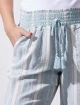 Pantalón de lino con pretina ancha en punto smock con lazo, bolsillos verticales delanteros y bolsillos aplicados traseros.