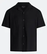 Camisa de hombre color verde claro, corte slim, de manga corta y cuello inglés. Confeccionada en viscosa texturizada.