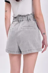 Short de jean gris con cintura paper bag, elástica y con botón. Tiene bolsillos delanteros y traseros.