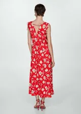 Vestido midi blanco con estampado floral verde, escote en V, tirantes finos con lazos y cintura elastizada.