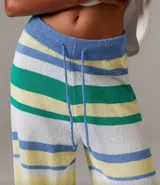 Pantalón de punto con cintura elástica y cordón ajustable, con diseño a rayas horizontales en tonos azul, amarillo, blanco y verde.